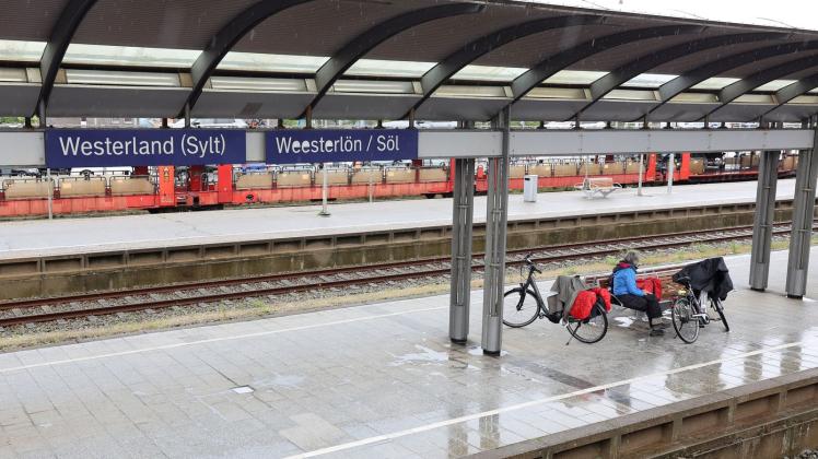 Nur wenige Reisende sind bei regnerischem Wetter am Bahnhof Westerland (Sylt) zu sehen. Foto: Bodo Marks/Bodo Marks/dpa