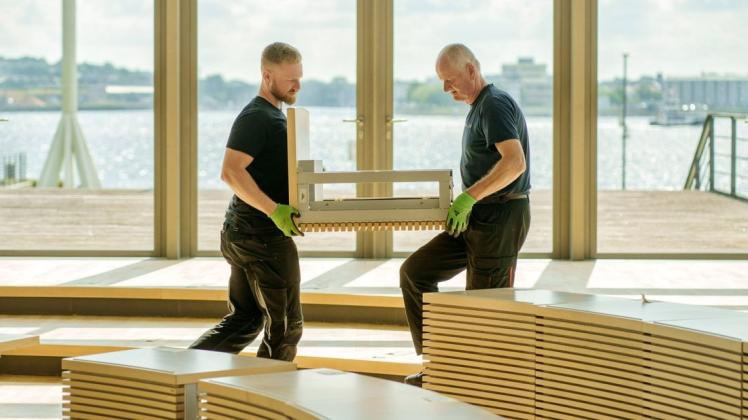 Der Landtag in Kiel wird momentan für die kommende Legislatur vorbereitet - Sebastian Pagel und Andre Reetz tragen die eingelagerten Tische wieder an ihre Plätze.