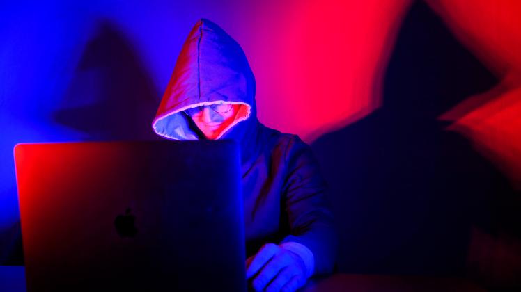 Cyberkriminalität Ein Mann mit Kapuzenpullover sitzt vor einem Laptop. Wuppertal Nordrhein-Westfalen Deutschland *** Cyb