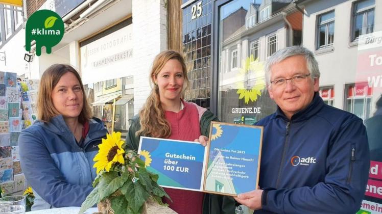 Julia Sievers-Langer (von links) und Hannah Hoffmann von der Ortsgruppe der Grünen verleihen dem ADFC-Vorsitzenden Reiner Hinsch die "Grüne Tat" für sein Engagement für die Verkehrswende.