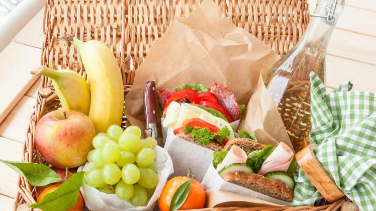 Filled picnic basket with sandwiches and fresh fruits (BarbaraNeveu)