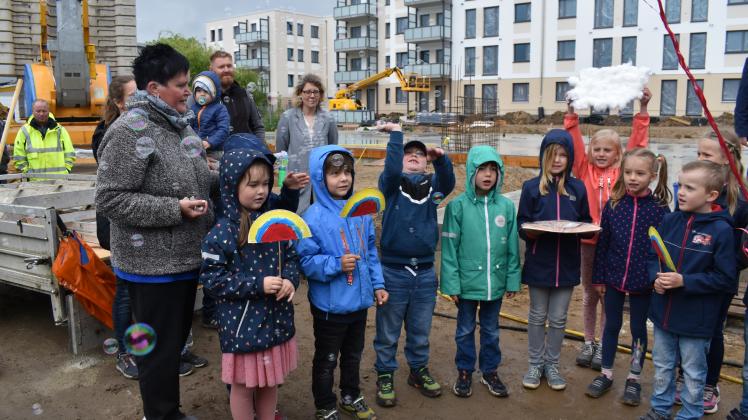 Mit einem kleinen Handwerker-Programm feiern die Kinder der Eulengruppe aus der Kita „Villa Traumland“ die Grundsteinlegung für den Krippenneubau in der Lagerstraße. 
