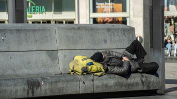 ARCHIV - Ein Obdachloser liegt auf einer Bank. Foto: Paul Zinken/dpa-Zentralbild/ZB/Symbolbild