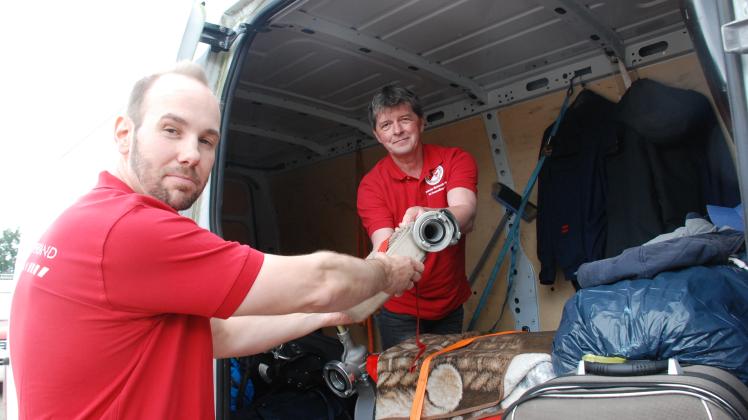 Marcus Giese (l.) und Frank Zander von der Wettkampfmannschaft der Freiwilligen Feuerwehr Wittenberge beladen einen Transporter.