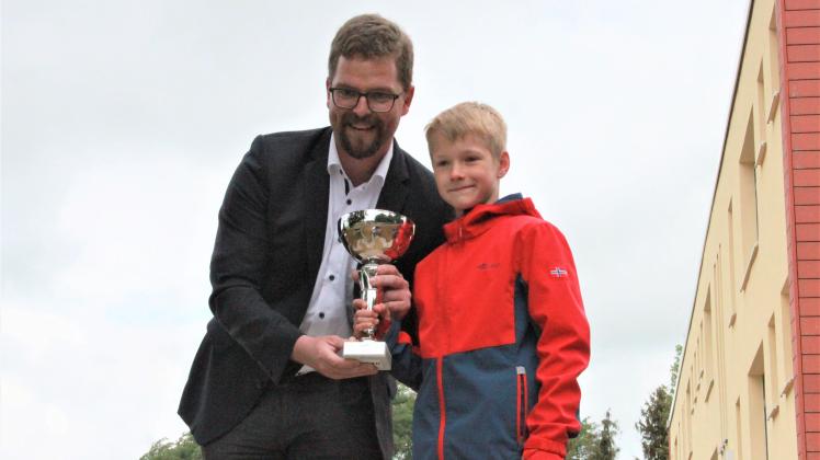 Bürgermeister Christian Greger übergibt den Pokal für die Kreismeister im Vierkampf der Grundschulen
