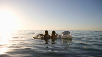 Twin sisters paddle out to sea on air bed, model released, , 10129938.jpg, Outdoors,Day,Adventure,Long Hair,Child,Childh