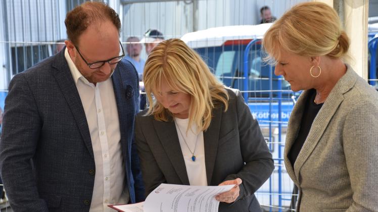 Steffen Bockhahn, Rostocks Sozialsenator (Linke), und Sigrid Hecht, KOE-Chefin, nehmen die Bescheide von Bildungsministerin Simone Oldenbourg entgegen.