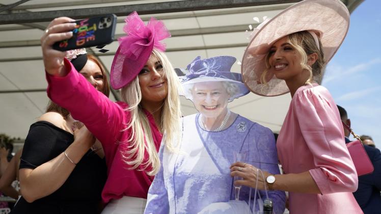 dpatopbilder - Fast wie in echt: Besucherinnen des Cazoo Derby in Surrey posieren für ein Selfie mit einem Pappausschnitt der Queen. Doch nicht alle Briten sind Fans der Monarchie. Foto: Andrew Matthews/PA Wire/dpa