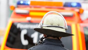 Feuerwehrmann vor einem Einsatzfahrzeug mit Blaulicht Symbolbild Themenbild Feuerwehr 25 09 17 So