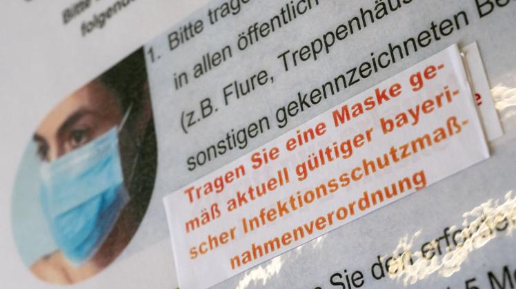 Ein Aufkleber mit der Aufschrift "Tragen Sie eine Maske gemäß aktuell gültiger bayerischer Infektionsschutzmaßnahmenverordnung" ist an einem Hinweisschild im Amtsgericht in München zu sehen. Foto: Peter Kneffel/dpa