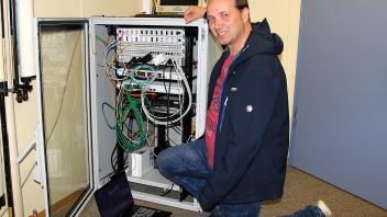 IT-Fachmann Jan-Martin Frick von der Verwaltung des Amtes Geltinger Bucht an einem von vier Netzwerkschränken in der Gemeinschaftsschule in Sterup.