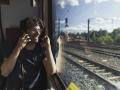 Happy man traveling by train talking on cell phone model released Symbolfoto PUBLICATIONxINxGERxSUI