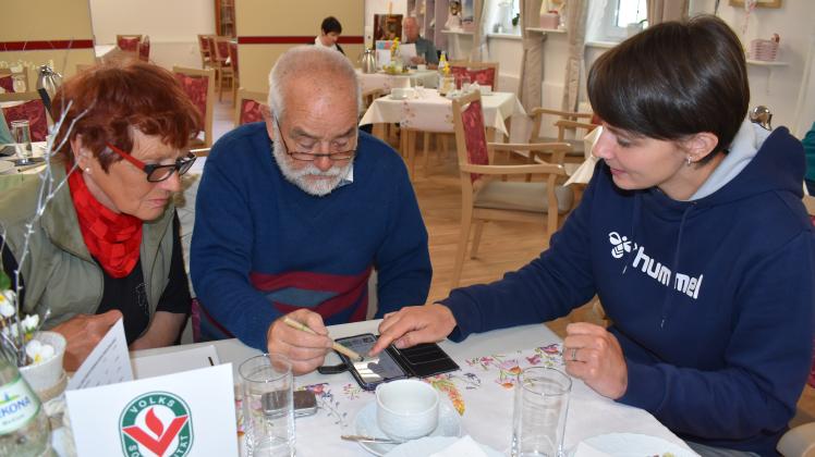 Monika Schirmeier vom Projekt „Digitale Engel“ zeigt Manfred Glöckner und Gudrun Wilken (l.), welche Apps kostenlos auf das Smartphone heruntergeladen werden können. 