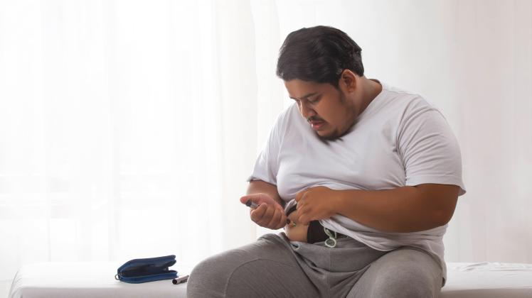 A fat fan trying to treat obesity with syringe by applying insulin injection to himself. PUBLICATIONxNOTxINxIND SLSK0098