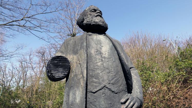 ARCHIV - Das Denkmal des Philosophen Karl Marx steht ohne rechten unterarm an seinem Platz in einem Park. Foto: Bernd Wüstneck/dpa/Archivbild
