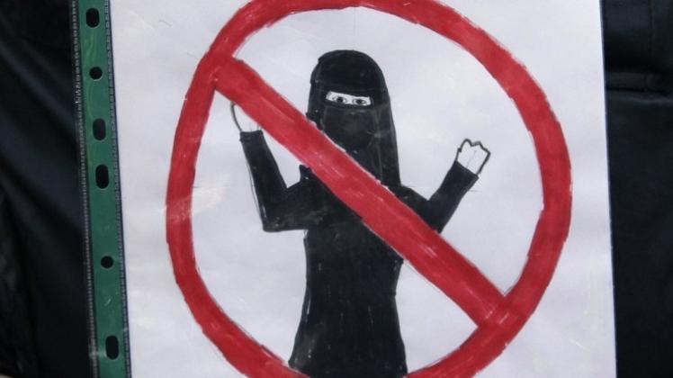 Mit klaren Stereotypen – der voll verschleierten Frau – arbeitet dieses Plakat, das sein Träger auf einer anti-islamischen Demonstration in die Höhe hält. 