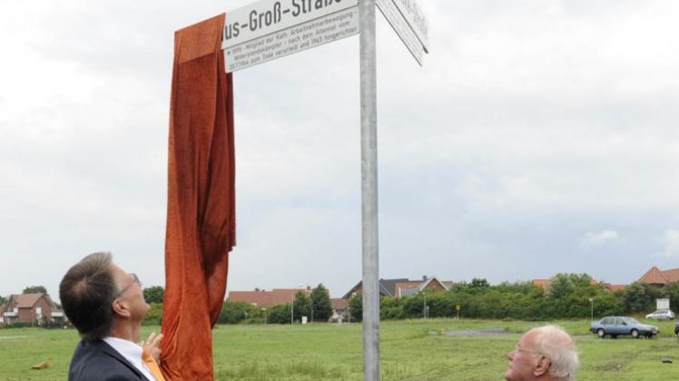 Bürgermeister Ulrich Belde (l.) und Bernhard Groß enthüllen das Straßenschild, das auf Nikolaus Groß hinweist, der 1945 von den Nationalsozialisten erhängt wurde. 