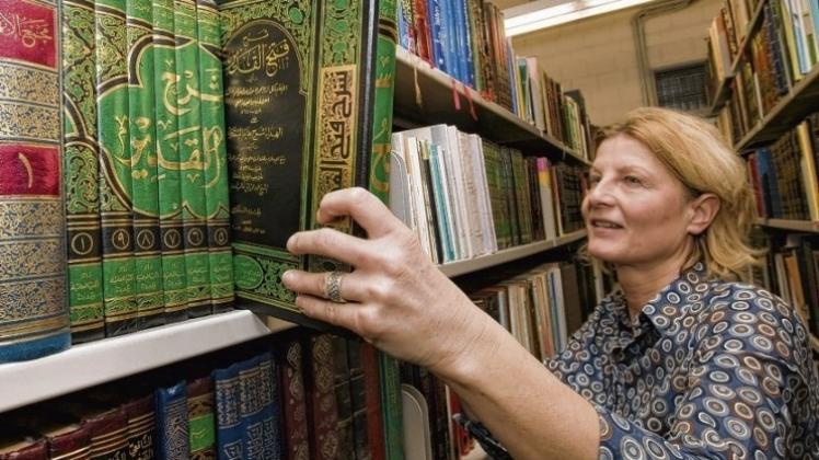Schön, aber schwer zu verstehen: Bibliotheksmitarbeiterin Christine Menkens bewundert die arabischen Schriftzeichen auf den frisch eingetroffenen Büchern. 