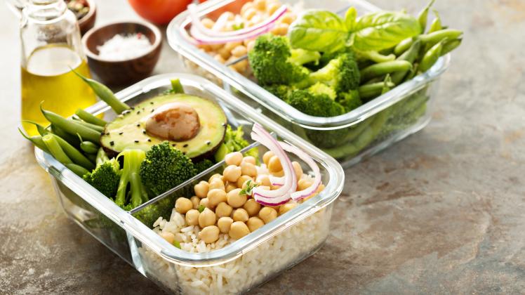 Vegan meal prep containers with cooked rice, chickpeas and vegetables (fahrwasser)