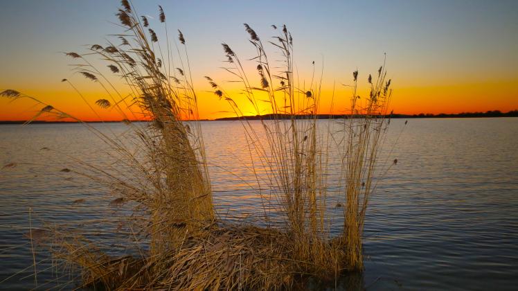 Blick am Donnerstag (06.01.2022) in Verchen (Landkreis Mecklenburgische Seenplatte) auf einen Sonnenuntergang am Kummer