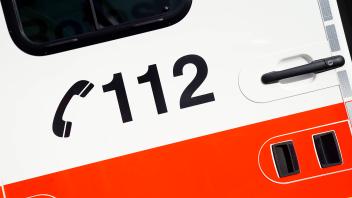 Symbolbild Rettungsdienst, Deutsches Rotes Kreuz Symbolfoto Aufschrift der Telefonnummer 112 auf einem Rettungswagen (R