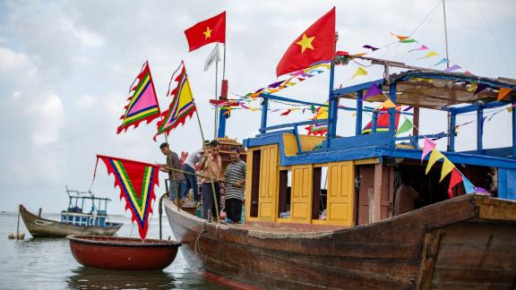 PRODUKTION - Einheimische Fischer und ältere Gläubige besteigen das Tempelboot im Rahmen des Walanbetungsfestes von Tam Hai. Foto: Chris Humphrey/dpa PRODUKTION - Einheimische Fischer und ältere Gläubige besteigen das Tempelboot im Rahmen des Walanbetungsfestes von Tam Hai. Foto: Chris Humphrey/dpa