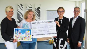 Spendenübergabe: Birgit Klockow (l.) und Andreas Gruczek, Geschäftsführer vom medienhaus:nord, übergeben den symbolischen Scheck an Liudmyla Sientsova und Natalia Jentzsch (2.v.r.) vom Schweriner Verein Ukrainisch-Deutsches Kulturzentrum.  