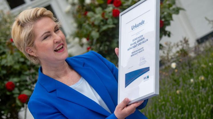 Ministerpräsidentin Manuela Schwesig (SPD) mit einer Urkunde für die Tourismusregion Mönchgut-Granitz. Foto: Stefan Sauer/dpa