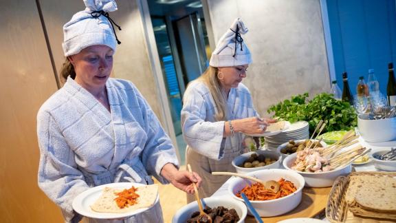 Kochbuchautorin Katariina Vuori (l) und die finnische Botschaftsrätin Tanja Huutonen belegen ihre Mittsommer-Wraps mit Lachs und Rentierfleisch. Foto: Florian Schuh/dpa-tmn - ACHTUNG: Nur zur redaktionellen Verwendung im Zusammenhang mit dem genannten Text Kochbuchautorin Katariina Vuori (l) und die finnische Botschaftsrätin Tanja Huutonen belegen ihre Mittsommer-Wraps mit Lachs und Rentierfleisch. Foto: Florian Schuh/dpa-tmn - ACHTUNG: Nur zur redaktionellen Verwendung im Zusammenhang mit dem genannten Text