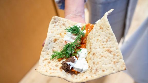 Der Tortilla-Fladen wird mit gebratenen Karotten, Lachs, Rentierfleisch, Dill und Sour Cream gefüllt und muss nur noch zugewickelt werden. Foto: Florian Schuh/dpa-tmn Der Tortilla-Fladen wird mit gebratenen Karotten, Lachs, Rentierfleisch, Dill und Sour Cream gefüllt und muss nur noch zugewickelt werden. Foto: Florian Schuh/dpa-tmn