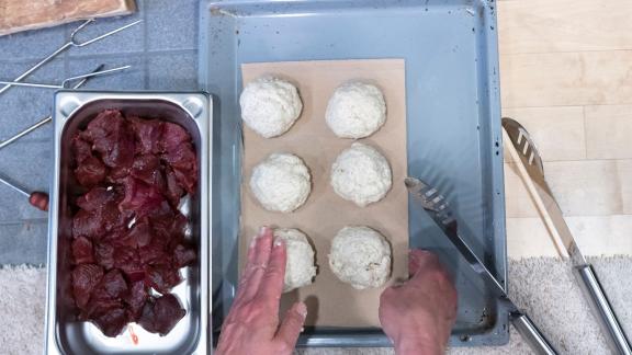 Die Rentierfleich-Stückchen werden in die fertig geformten Salzteigbällchen gedrückt. Foto: Florian Schuh/dpa-tmn Die Rentierfleich-Stückchen werden in die fertig geformten Salzteigbällchen gedrückt. Foto: Florian Schuh/dpa-tmn