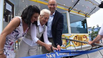 Für die Schaustellerin Katrin Geisler ist es ein großer Moment, als Bürgerschaftspräsidentin Regine Lück (Linke) und Tourismusdirektor Mattias Fromm die blaue Schleife beim Riesenrad durchtrennen. 
