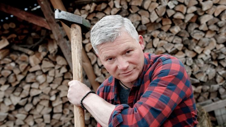 ARCHIV - Autor Andreas Winkelmann spaltet auf seinem Grundstück Holz für den Kamin. Foto: Markus Scholz/dpa