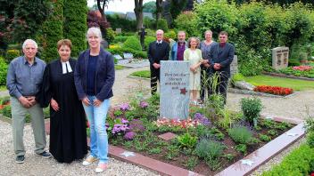 Rudi Pagel, Pastorin Simone Liepolt und Susanne Behrendsen (vorne) an der neu eingerichteten Grab- und Gedenkstelle für Sternenkinder auf dem Friedhof in Grundhof.