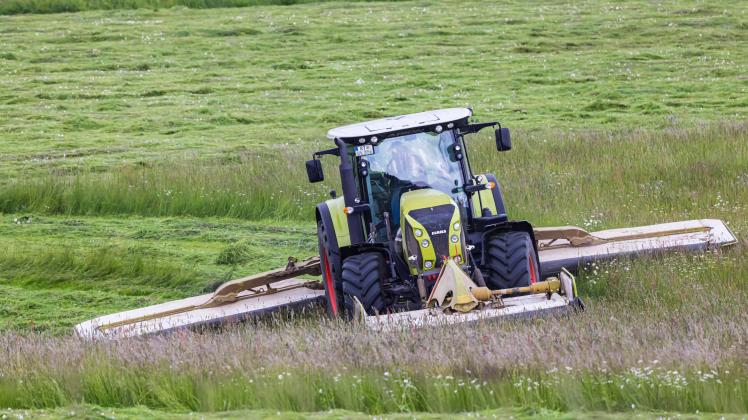 Landwirt beim Mähen seiner Felder mit dem Traktor. // 10.06.2022: Deutschland, Baden-Württemberg, Grabenstetten. *** Far