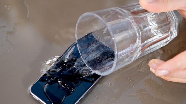 ILLUSTRATION - Wasser und Smartphone vertragen sich in der Regel nicht so gut. Wie lässt sich ein Gerät dennoch retten, wenn Feuchtigkeit eingedrungen ist? Foto: Zacharie Scheurer/dpa-tmn