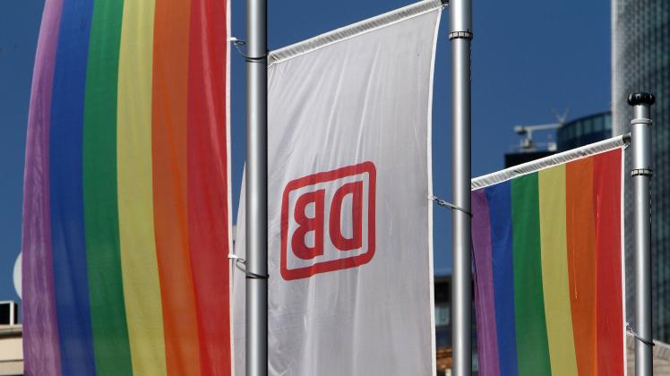 Eine Flagge mit dem Logo der DB Deutsche n Bahn wird in Frankfurt von zwei Regenbogenflaggen eingerahmt, Hessen, Deutsch