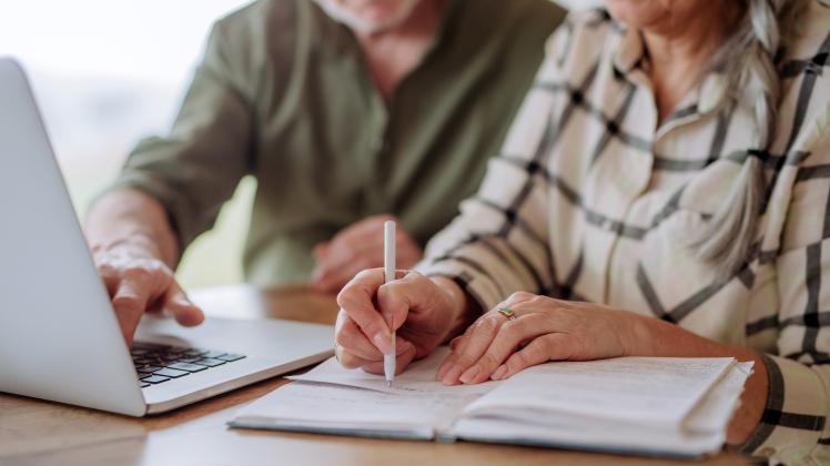 Close up, senior couple calculate expenses or planning budget together at home.