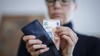 Symbolfoto. Eine Frau nimmt Geldscheine aus einer Geldboerse. Berlin, 06.04.2020. Berlin Deutschland *** Symbol photo A