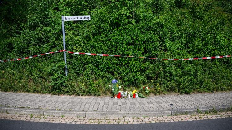 Kerzen, Blumen und Figuren zum Gedenken an eine getötete 15-jährige liegen an einem Tatort an einer Grünfläche am Hans-Böckler-Ring. Foto: Julian Stratenschulte/dpa