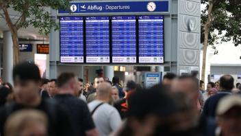 Reisende gehen durch den Flughafen Düsseldorf. Der Ferienstart im bevölkerungsreichsten Bundesland Nordrhein-Westfalen dürfte am Wochenende zu stundenlangen Wartezeiten führen. Foto: David Young/dpa