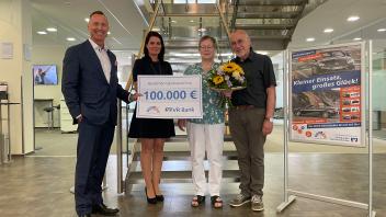 Lars Nissen (Vorstandssprecher, v.l.) und Kathleen Wendland (Kundenberaterin) gratulieren Magda und Burkhard Smolka zum Gewinn von 100.000 Euro.