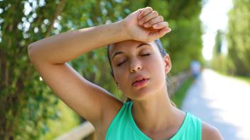 Close up of young woman taking a break from working out outside tired with arm over head. Copyright: xSERGIOxMONTIx 3676