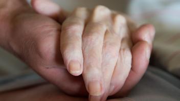 ARCHIV - Ein Altenpfleger hält in einem Pflegeheim die Hand einer Frau. Der Bundestag hat sich mit konkreten Vorschlägen zur Regelung der Sterbehilfe in Deutschland befasst. Foto: Sebastian Kahnert/zb/dpa