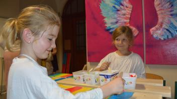 Die Schülerinnen Nele Sophie (l.) und Phoebe malen drinnen – nicht draußen wie eigentlich geplant. Die Schüler der Fehrs-Schule spendeten an den Blauen Elefanten und an die Tafel.