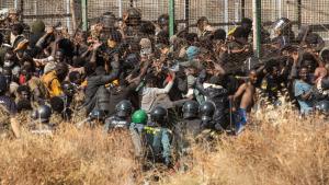 Migranten kommen auf spanischem Boden an, nachdem sie die Zäune zwischen der spanischen Exklave Melilla und Marokko überquert haben. Foto: Javier Bernardo/AP/dpa