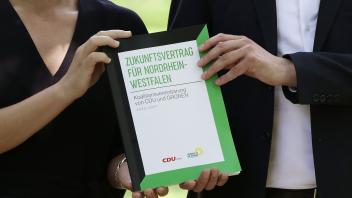 ARCHIV - Nordrhein-Westfalens Ministerpräsident Hendrik Wüst (CDU) und Grünen-Vorsitzende Mona Neubaur stellen den Koalitionsvertrag von Schwarz-Grün in NRW vor. Foto: David Young/dpa