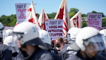G7-Demonstranten stehen Polizisten auf der Münchener Theresienwiese gegenüber. Foto: Michael Kappeler/dpa