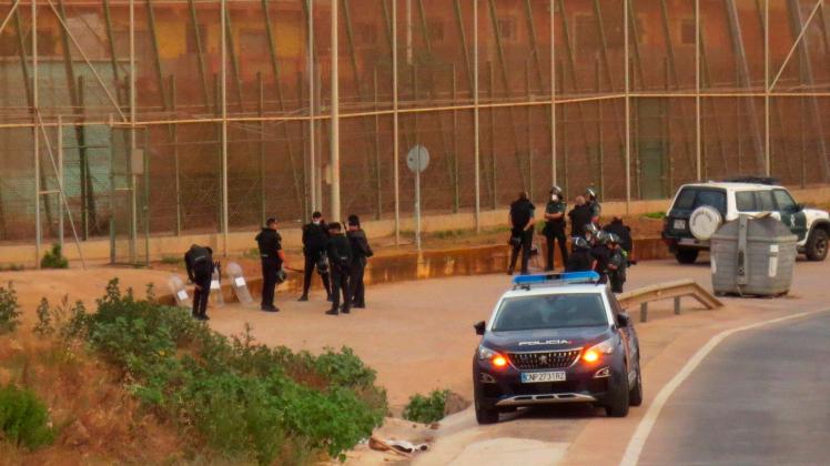 Spanish security forces members stand guard next to the border fence with Morocco after several migrants managed to jump
