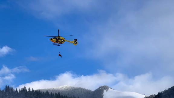 Einsatzkräfte der Bergrettung bergen eine verletzte Person mit einem Hubschrauber. Einsatzkräfte der Bergrettung bergen eine verletzte Person mit einem Hubschrauber.